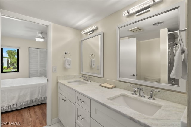 bathroom featuring a sink, visible vents, toilet, and double vanity