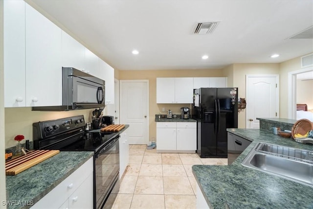 kitchen with visible vents, black appliances, a sink, dark countertops, and white cabinetry