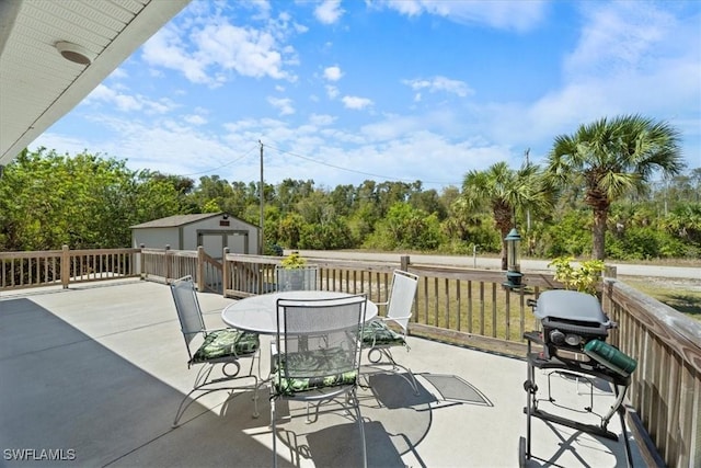 view of patio featuring an outbuilding, a storage unit, and outdoor dining area