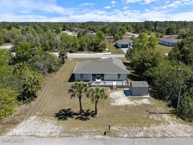 bird's eye view with a wooded view