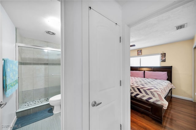 interior space with connected bathroom, visible vents, baseboards, and wood finished floors