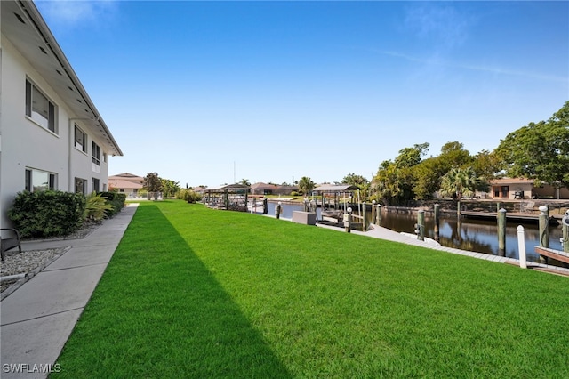 view of yard with a boat dock and a water view