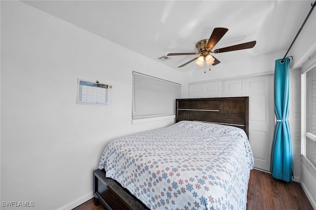 bedroom featuring dark wood finished floors, visible vents, ceiling fan, and baseboards