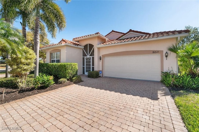 9011 Springview Loop, Estero, FL 33928 - mediterranean / spanish-style home featuring decorative driveway, an attached garage, and stucco siding