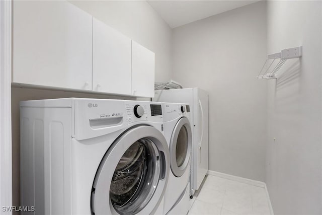 9011 Springview Loop, Estero, FL 33928 - laundry area with washer and clothes dryer, cabinet space, baseboards, and light tile patterned floors