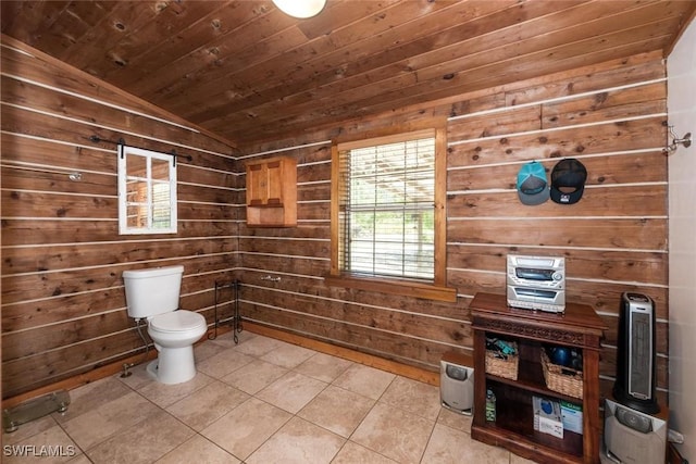 bathroom with wood walls, toilet, lofted ceiling, wooden ceiling, and tile patterned floors