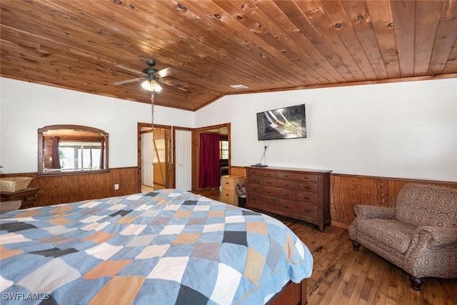 bedroom with lofted ceiling, wooden walls, wood ceiling, and wainscoting