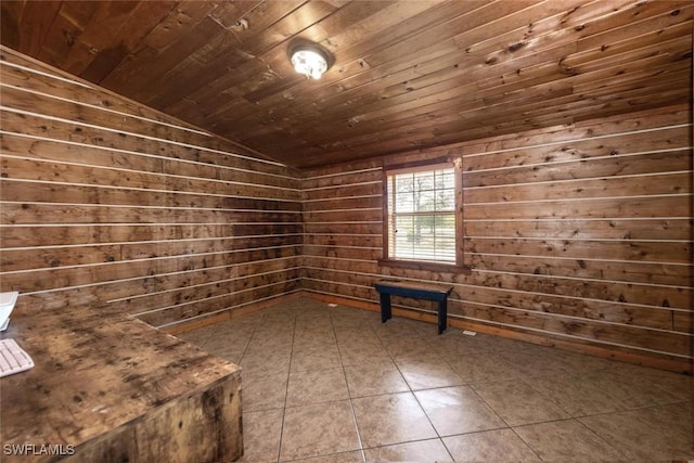 interior space with lofted ceiling, dark tile patterned floors, wood ceiling, and wood walls