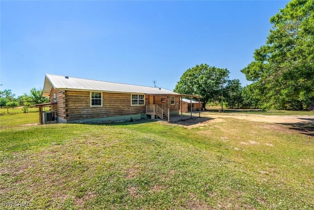 back of house with log exterior and a yard