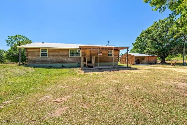 back of property featuring log siding and a lawn