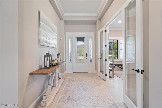 foyer entrance with crown molding, light tile patterned floors, french doors, and baseboards