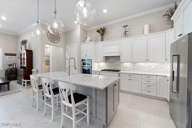 kitchen featuring a sink, ornamental molding, appliances with stainless steel finishes, and premium range hood