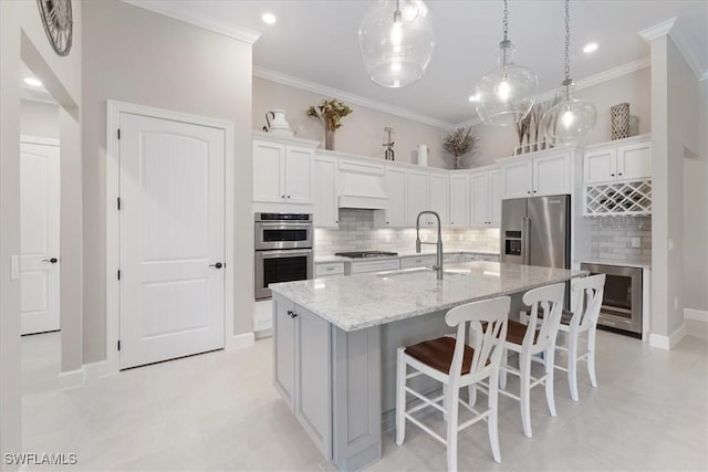 kitchen featuring a sink, stainless steel appliances, ornamental molding, and custom range hood