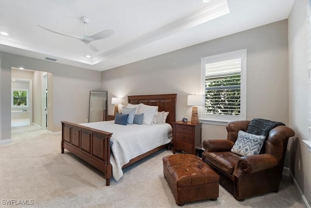 bedroom with a raised ceiling, multiple windows, visible vents, and light carpet