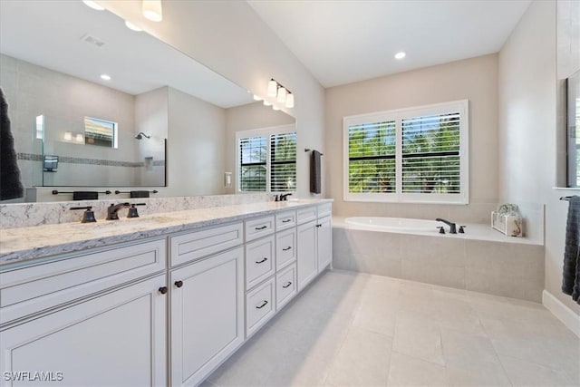 bathroom with double vanity, a sink, tile patterned flooring, a walk in shower, and a garden tub