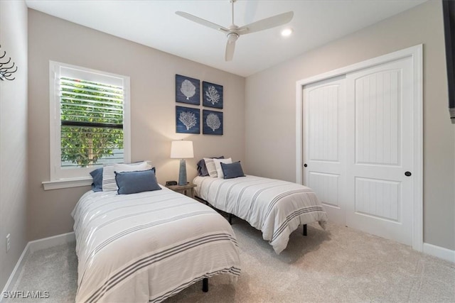 bedroom with a closet, baseboards, carpet floors, and a ceiling fan