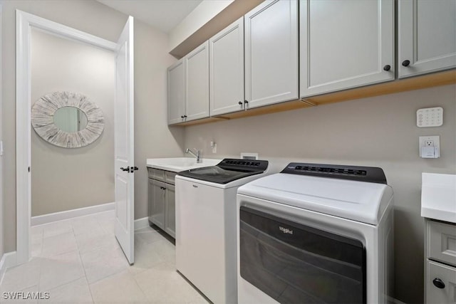 clothes washing area featuring baseboards, washer and dryer, light tile patterned flooring, cabinet space, and a sink