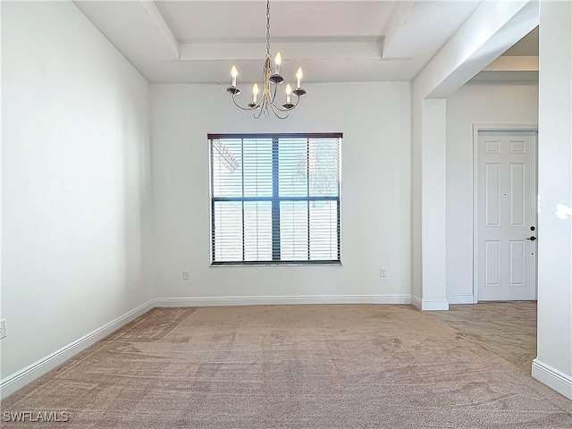 carpeted spare room featuring an inviting chandelier, a raised ceiling, and baseboards