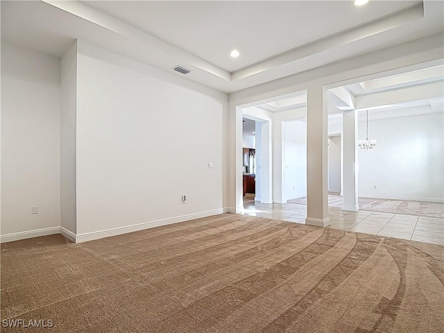 unfurnished room with visible vents, light carpet, a notable chandelier, and baseboards