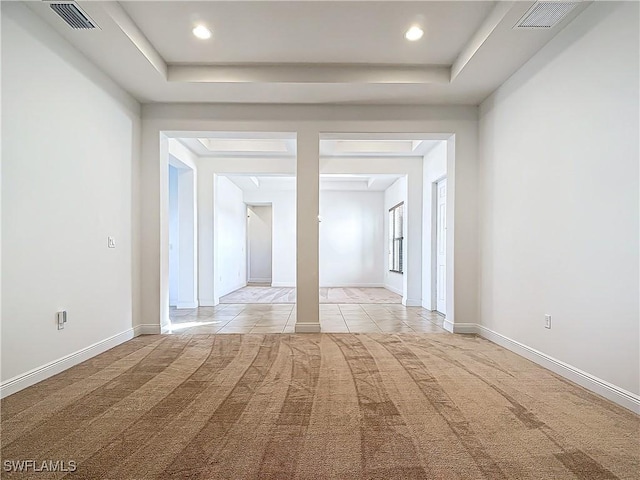 unfurnished room with visible vents, baseboards, and light colored carpet