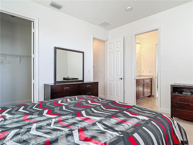 bedroom featuring baseboards, visible vents, and ensuite bathroom