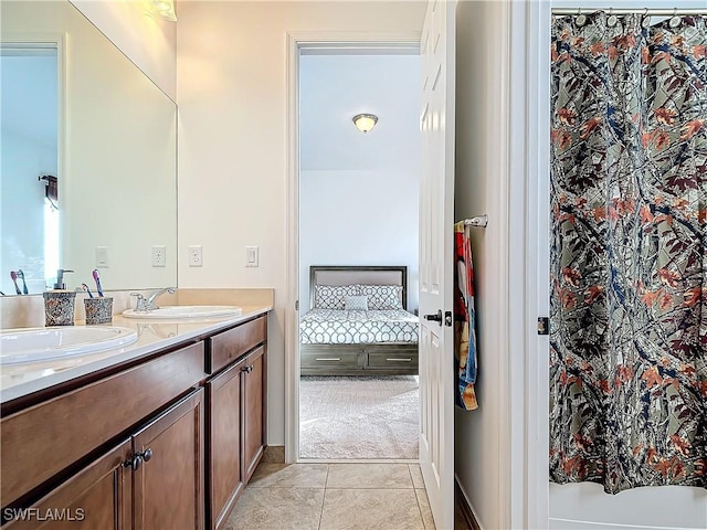 full bath featuring tile patterned floors, double vanity, ensuite bath, and a sink