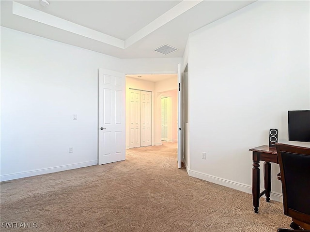 home office featuring a tray ceiling, visible vents, baseboards, and light carpet