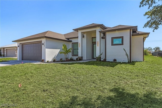 prairie-style home featuring a front lawn, an attached garage, driveway, and stucco siding