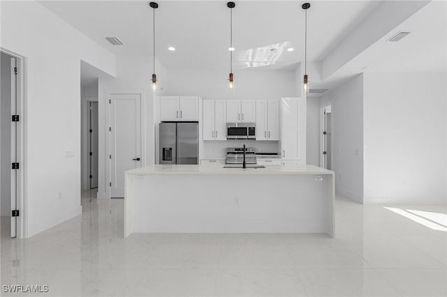 kitchen with visible vents, an island with sink, a sink, appliances with stainless steel finishes, and white cabinets