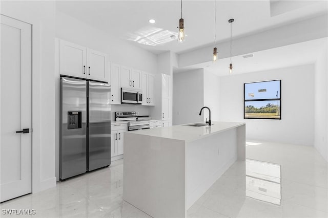 kitchen with a sink, light countertops, white cabinets, appliances with stainless steel finishes, and decorative light fixtures