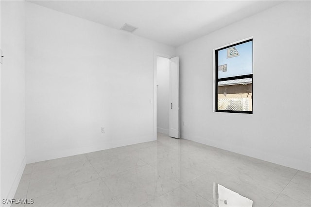 unfurnished room featuring visible vents and baseboards