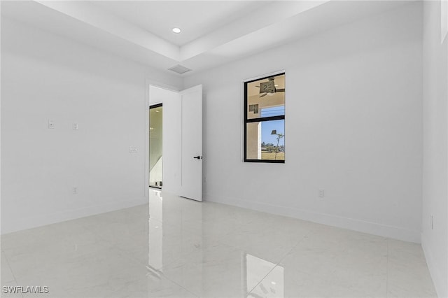 spare room featuring visible vents, recessed lighting, a raised ceiling, and baseboards