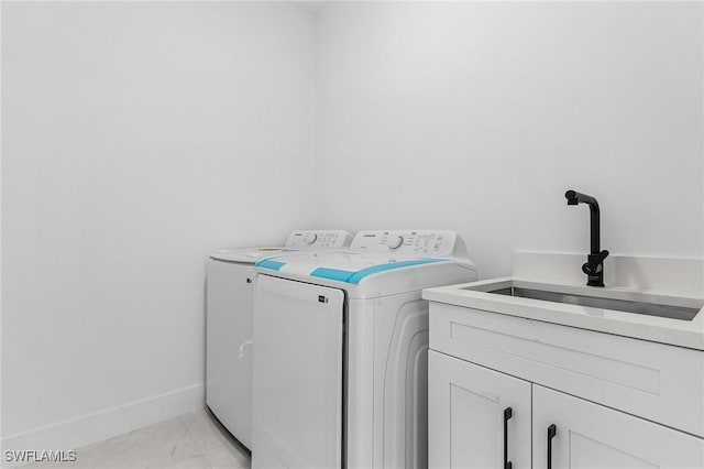 clothes washing area with marble finish floor, washer and dryer, a sink, cabinet space, and baseboards