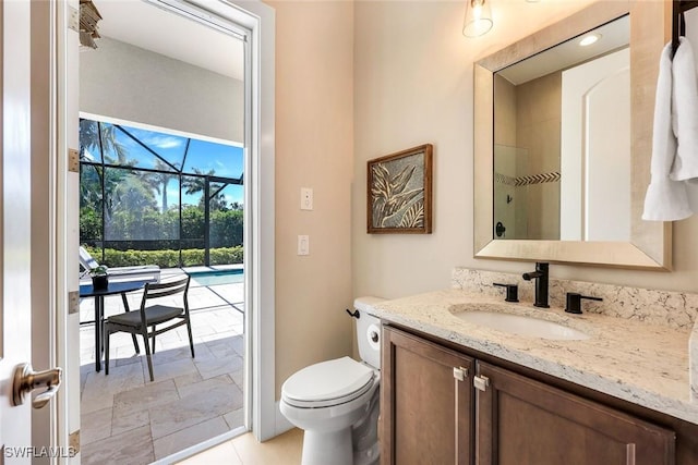 full bath featuring vanity, toilet, a shower, and stone tile flooring