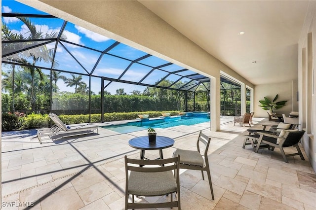 outdoor pool featuring glass enclosure and a patio area