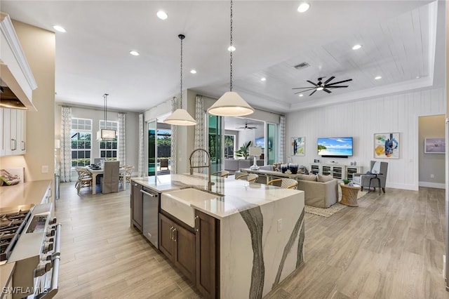 kitchen featuring visible vents, a ceiling fan, a sink, open floor plan, and appliances with stainless steel finishes