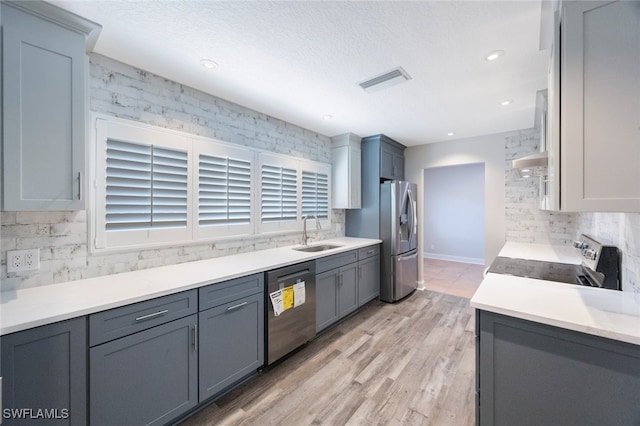 kitchen with visible vents, backsplash, appliances with stainless steel finishes, and a sink