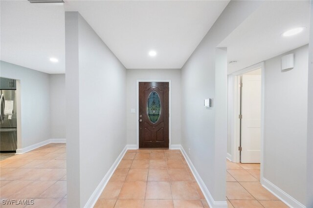 doorway featuring light tile patterned floors, recessed lighting, and baseboards