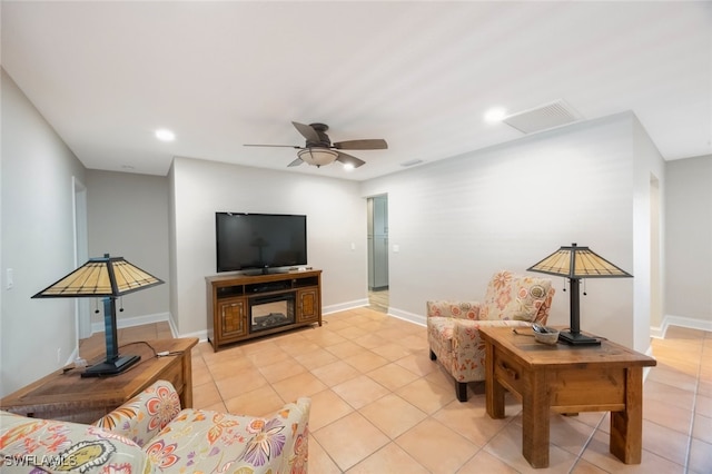 living area featuring light tile patterned flooring, visible vents, baseboards, and ceiling fan