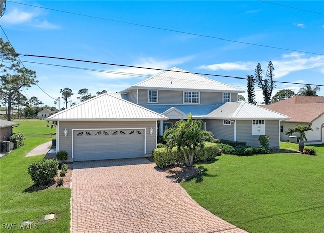 traditional-style house with a front lawn, decorative driveway, and a garage