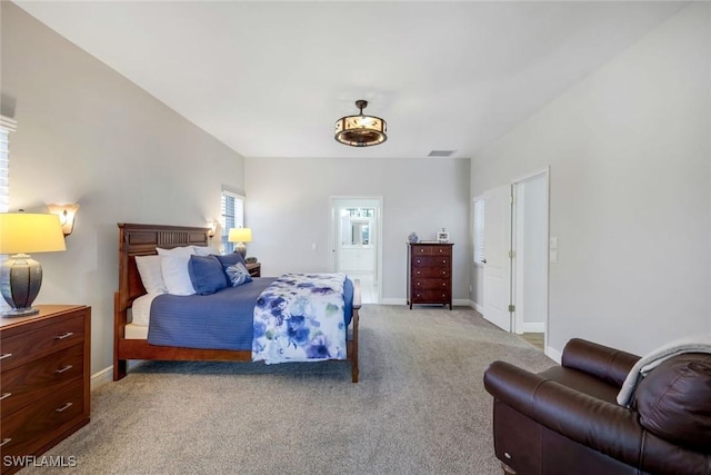 bedroom with visible vents, baseboards, light colored carpet, and ensuite bathroom