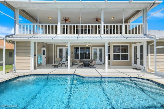 back of house with a patio, a balcony, french doors, and an outdoor pool