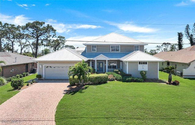 view of front of property featuring decorative driveway, a garage, metal roof, and a front lawn