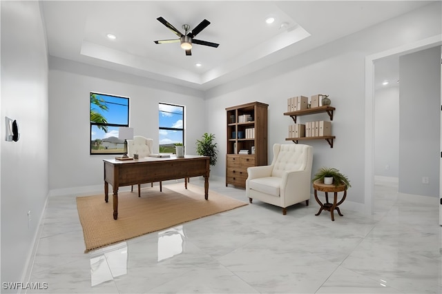 home office with marble finish floor, a tray ceiling, recessed lighting, baseboards, and ceiling fan