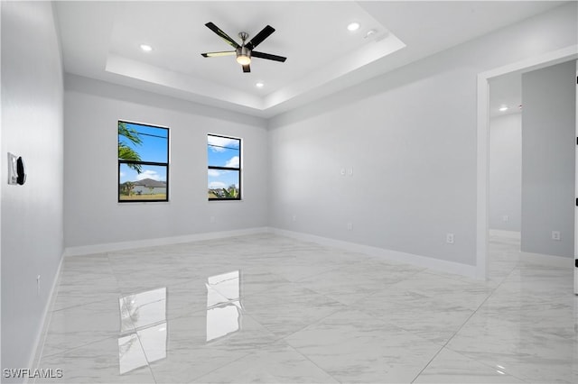 unfurnished room featuring recessed lighting, baseboards, a raised ceiling, and ceiling fan