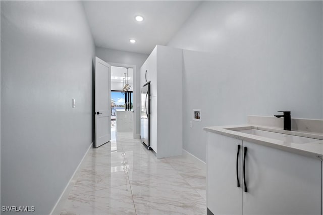 hall with recessed lighting, marble finish floor, baseboards, and a sink