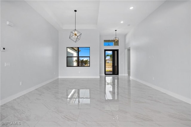 empty room with an inviting chandelier, recessed lighting, baseboards, and marble finish floor