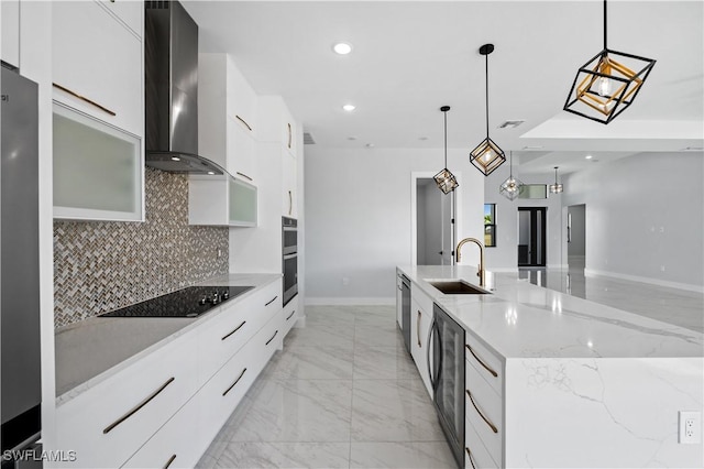 kitchen featuring modern cabinets, wall chimney exhaust hood, black electric cooktop, and a sink