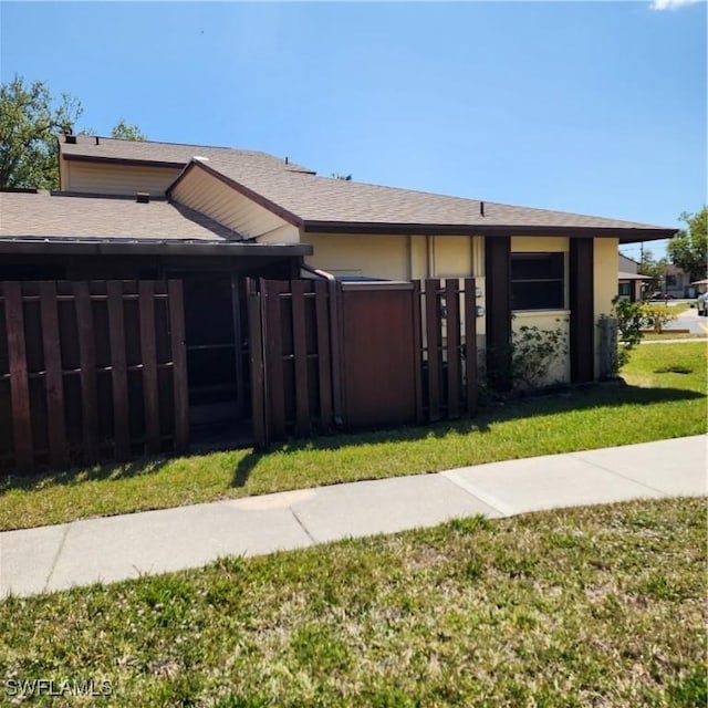 exterior space featuring stucco siding, a front yard, and fence