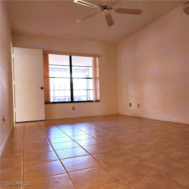 unfurnished room featuring light tile patterned floors, a ceiling fan, and a textured ceiling